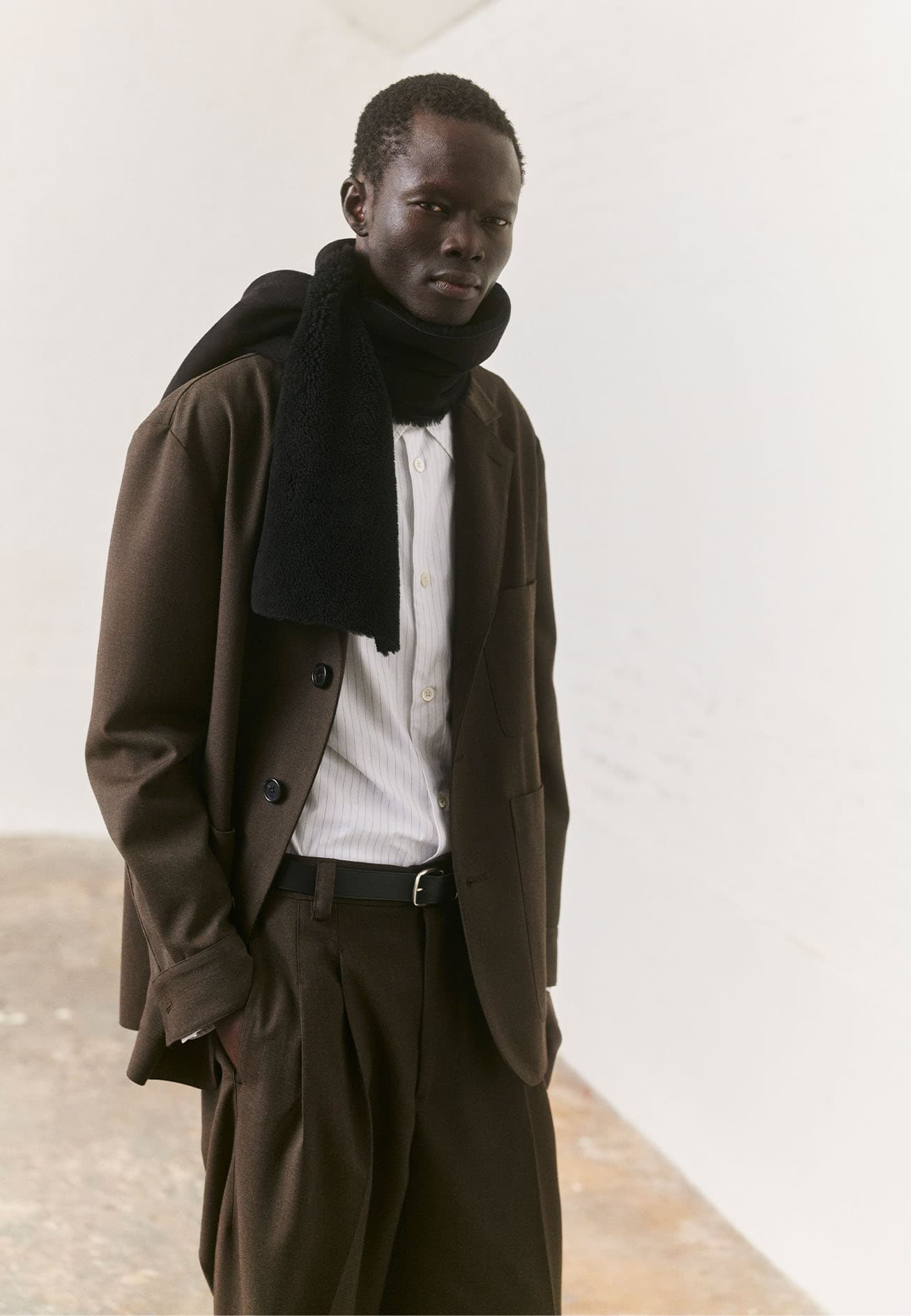 Margaret Howell AW25 official lookbook outfit with dark coat and relaxed scholar proportions.